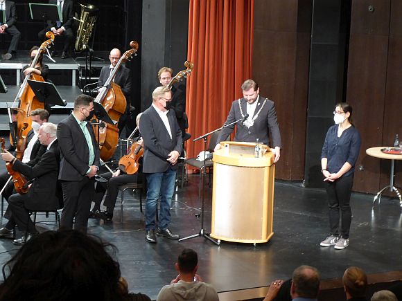 OB Kurzbach auf der Bühne mit drei Neubürgern zwischen den Musikern